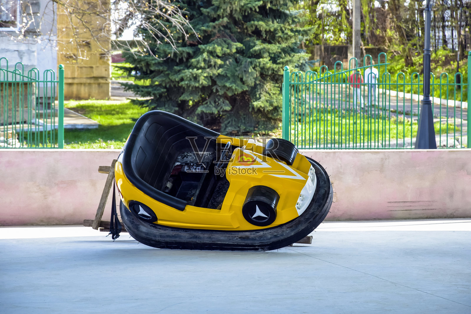 修理一辆损坏的黄色Bump车。儿童电动汽车。骑在Dodgem车上。儿童景点,游乐场。有选择性的重点。照片摄影图片