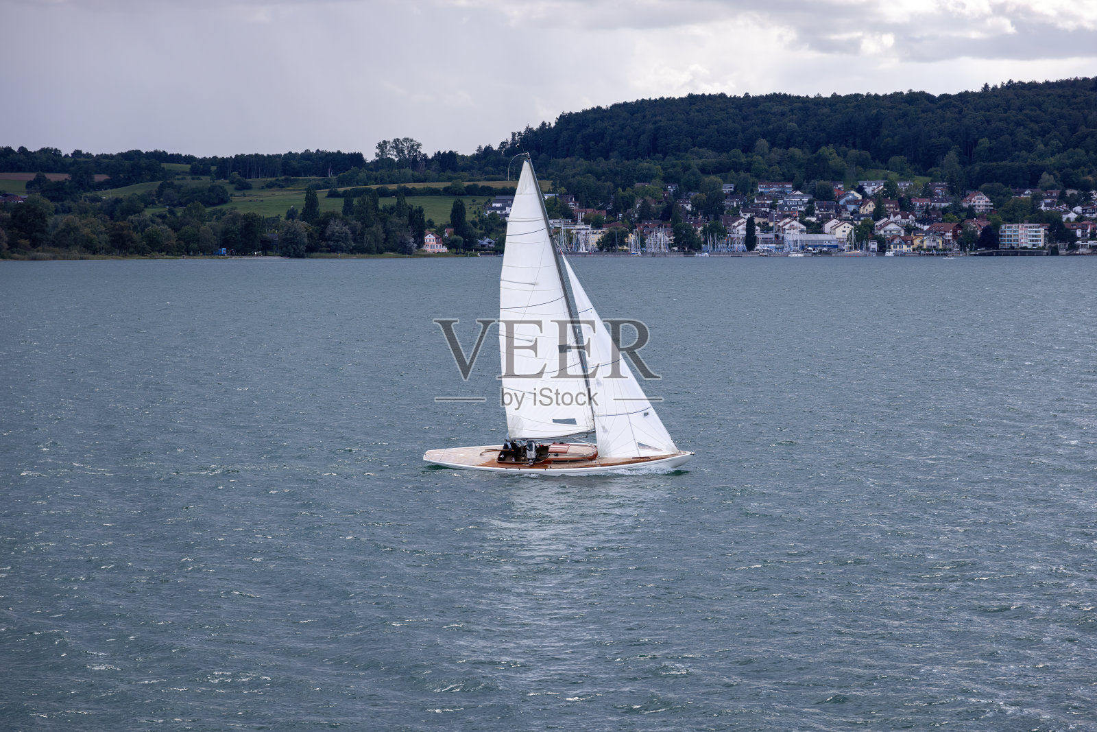 康斯坦斯湖上,一艘倾斜的帆船全速行驶。照片摄影图片