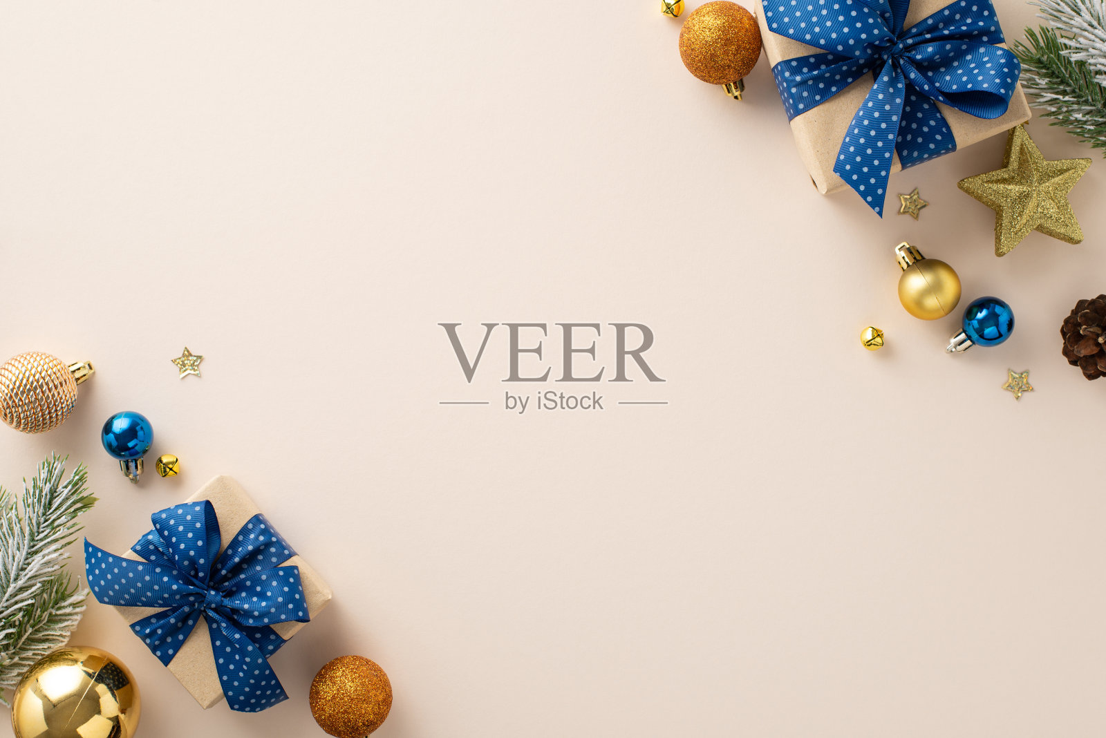 迷人的节日氛围:顶视图的节日礼盒,闪闪发光的装饰在蓝色,橙色,金色,松果,霜覆盖冷杉树枝在中性的背景。适合季节性信息或广告照片摄影图片