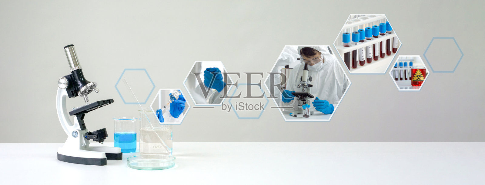 白色实验台上的显微镜和烧杯中的蓝色化学液体,显示实验室抗病毒药物研究的气氛。照片摄影图片