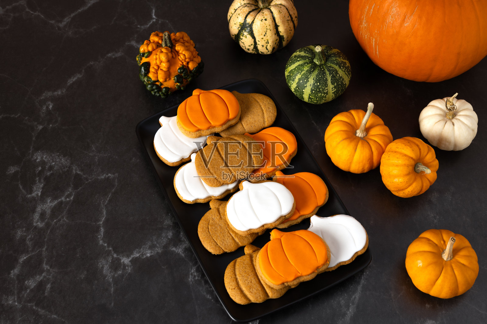 南瓜形状的姜饼饼干,黑色背景上有糖霜照片摄影图片