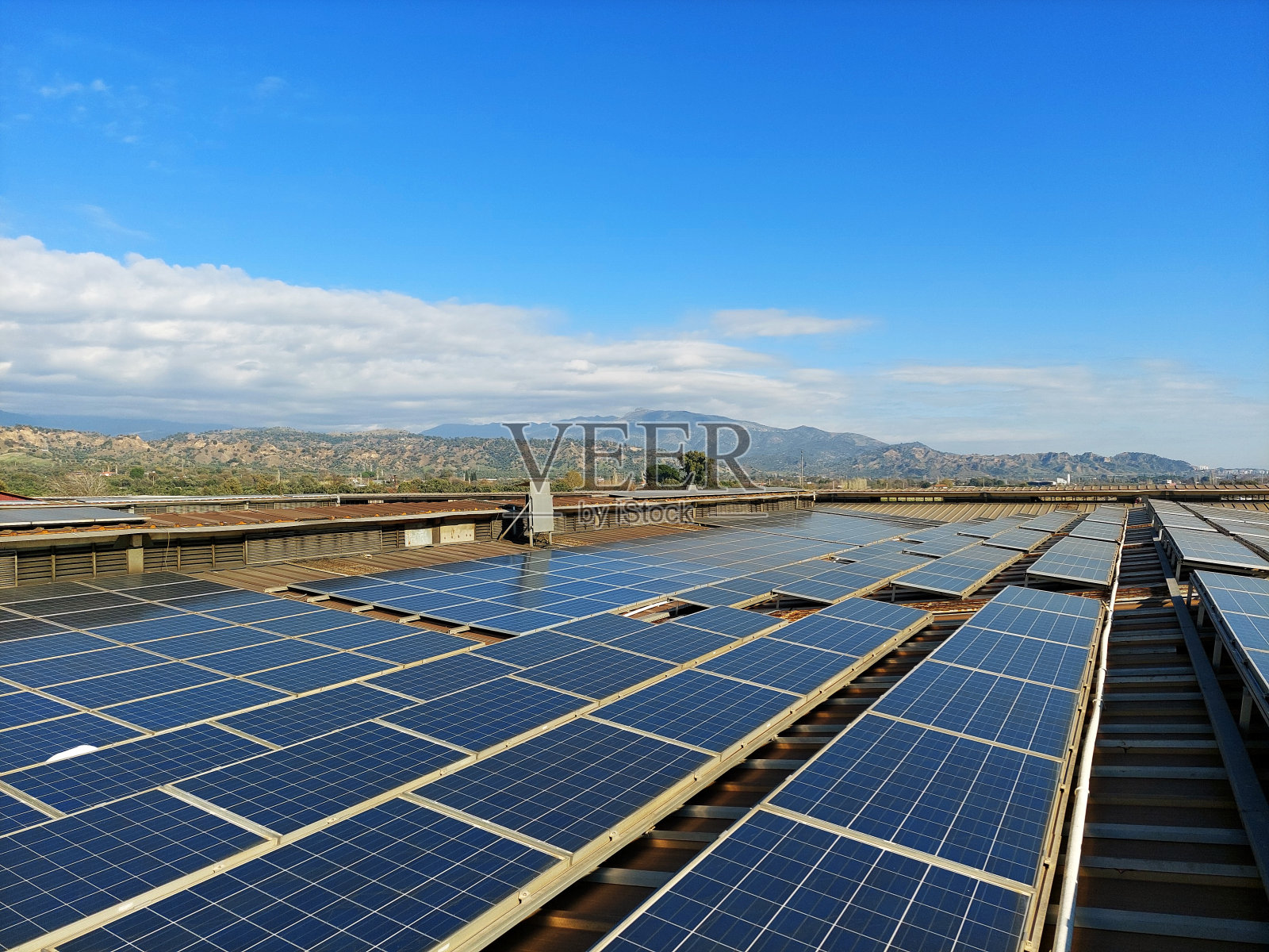太阳能电池板是在工业建筑的屋顶上使用水平可再生能源的照片摄影图片
