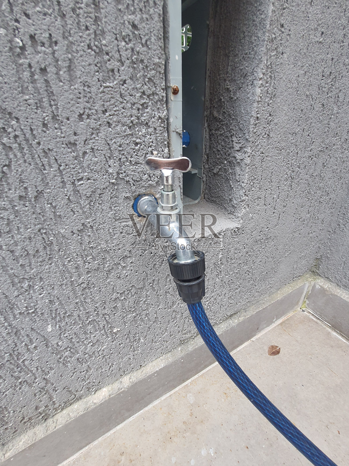 带橡胶软管的花园水龙头。照片摄影图片