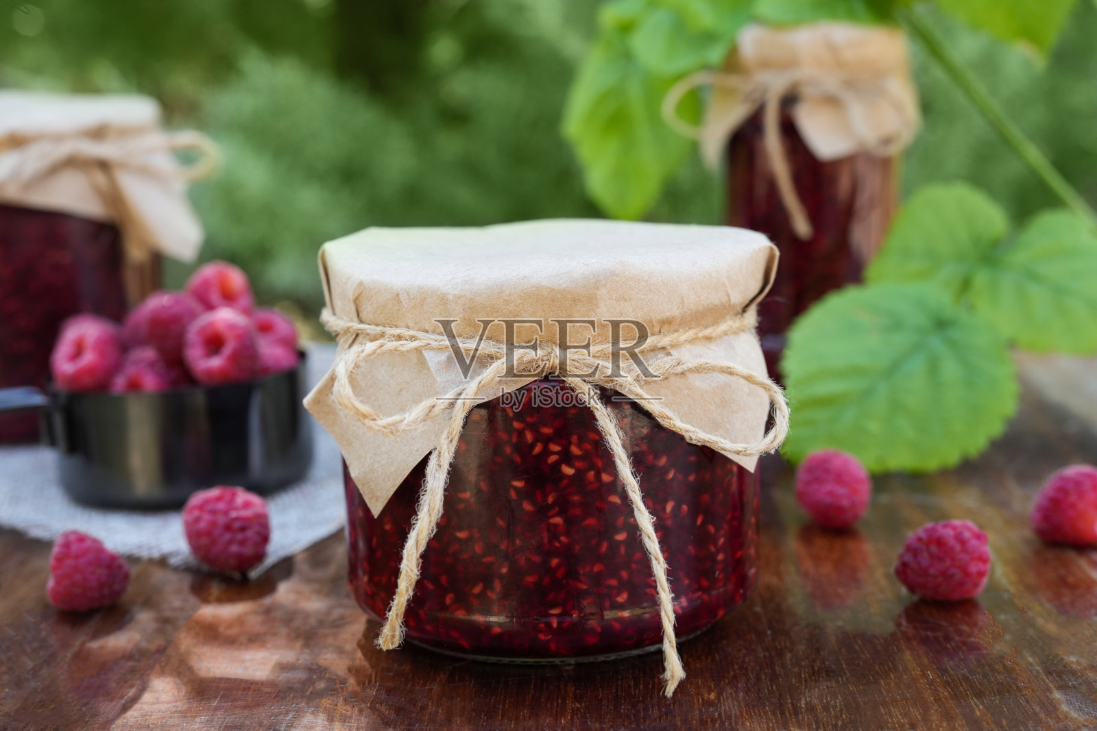 自制的覆盆子果酱,装在玻璃罐里。照片摄影图片