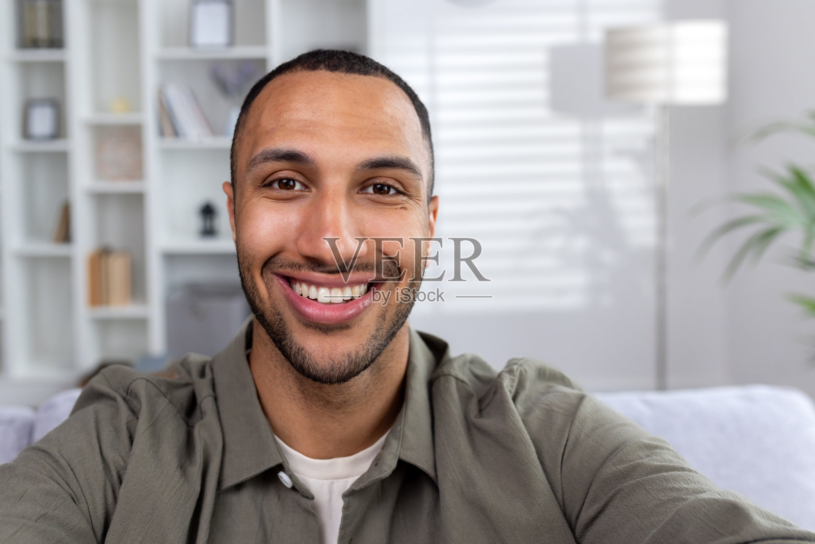 年轻的非裔美国男子在家进行视频通话,对着镜头微笑照片摄影图片