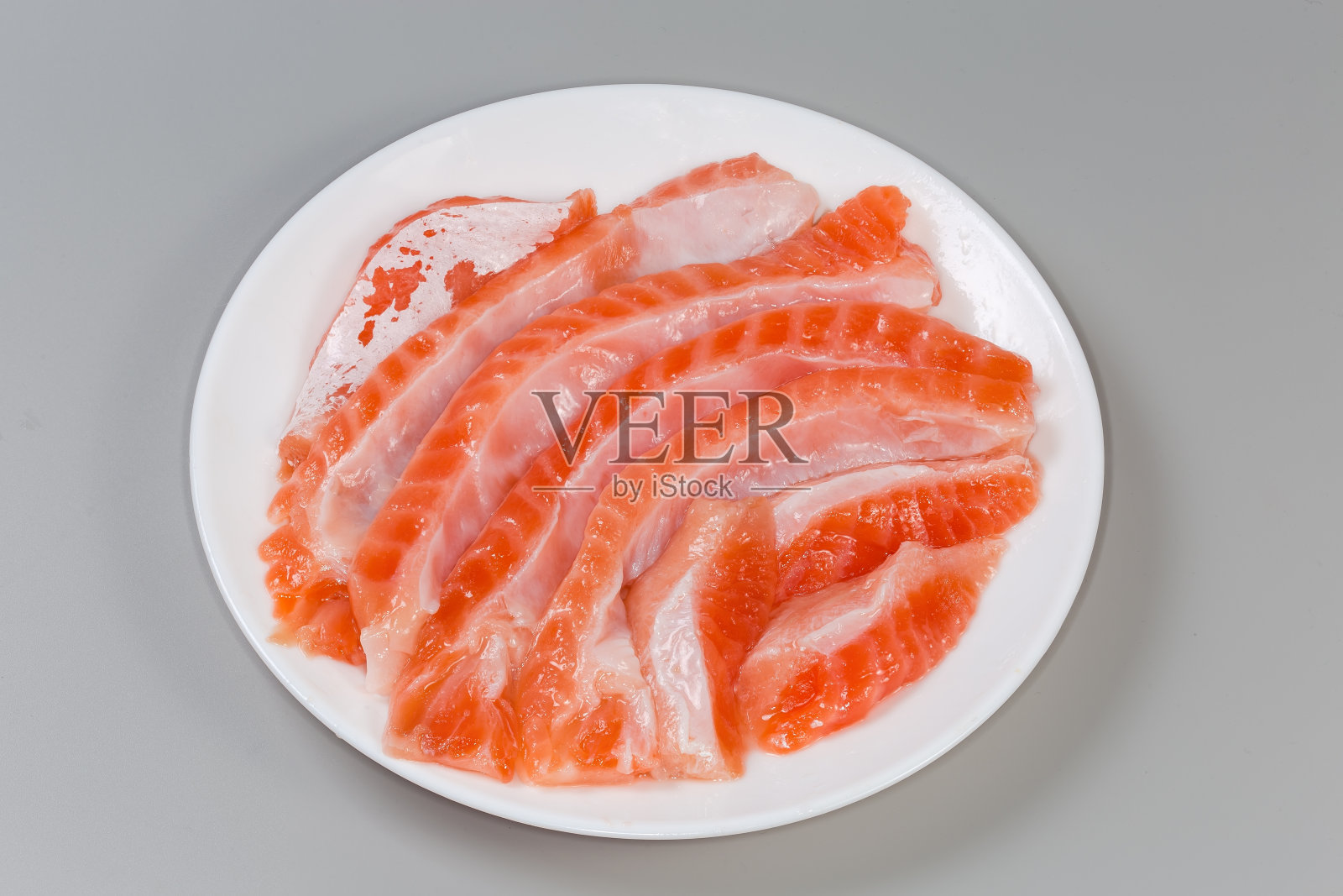 灰色背景上的咸味鲑鱼肚片照片摄影图片