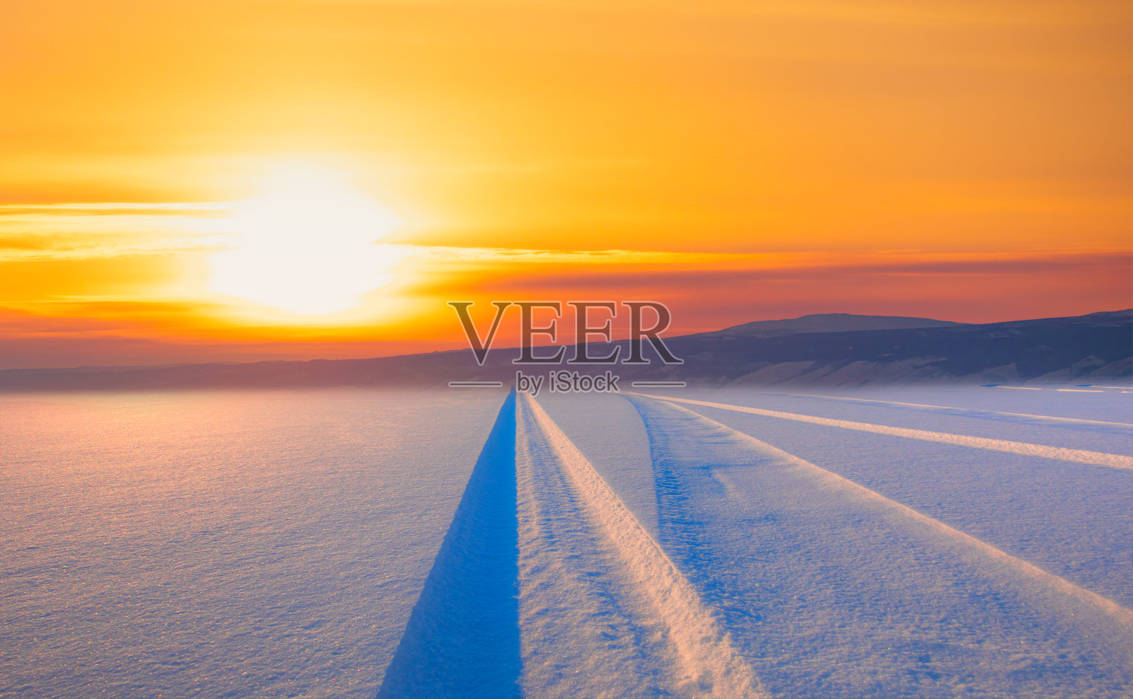 汽车轮胎的痕迹(踪迹)在新鲜的雪在惊人的日落-贝加尔湖,西伯利亚照片摄影图片