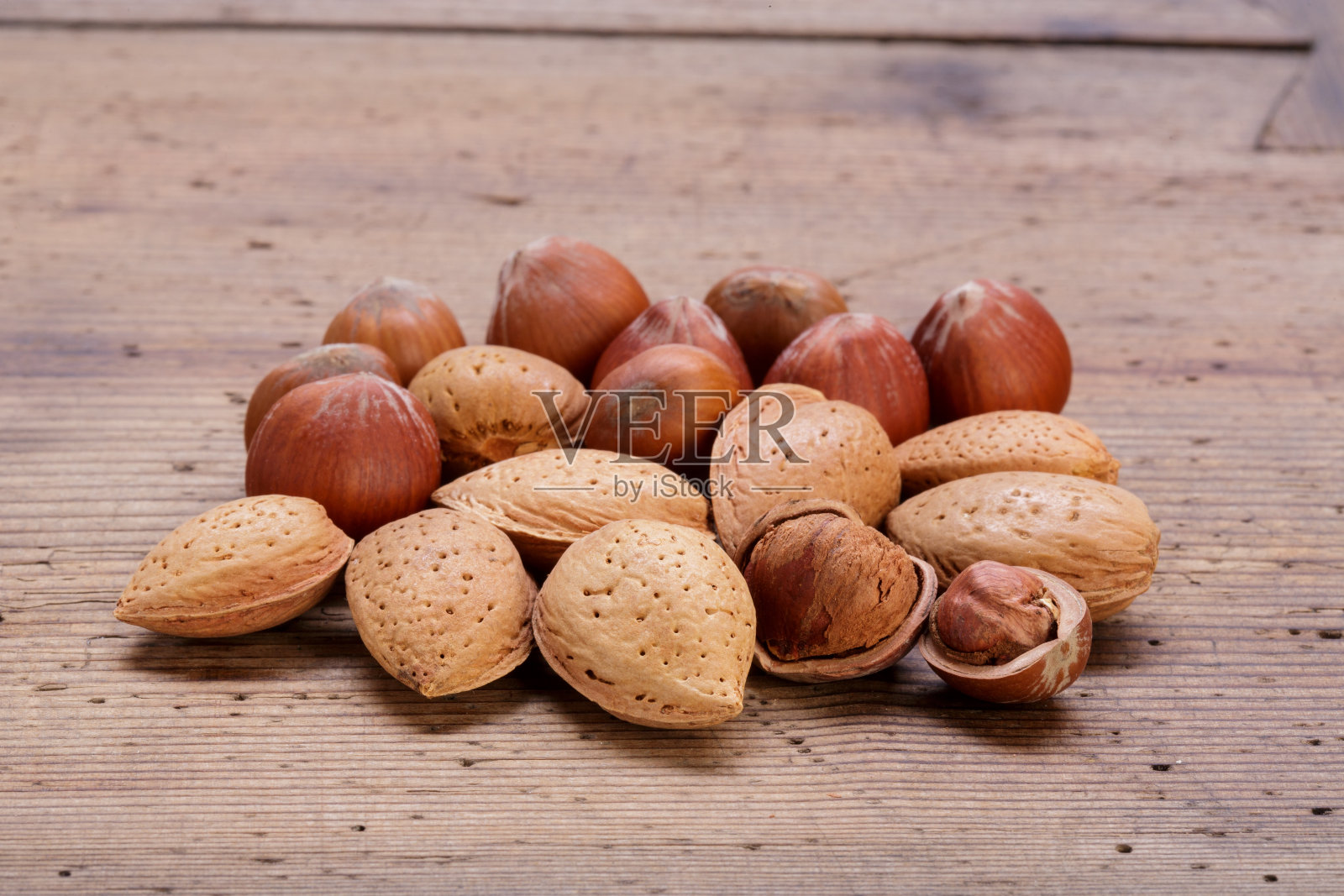 带壳的杏仁和榛子放在质朴的木桌上照片摄影图片