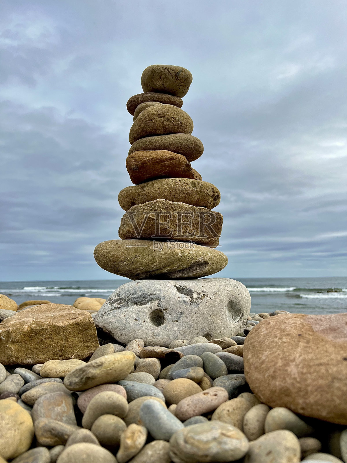 诺森伯兰郡圣岛岩石海岸线上的石堆照片摄影图片