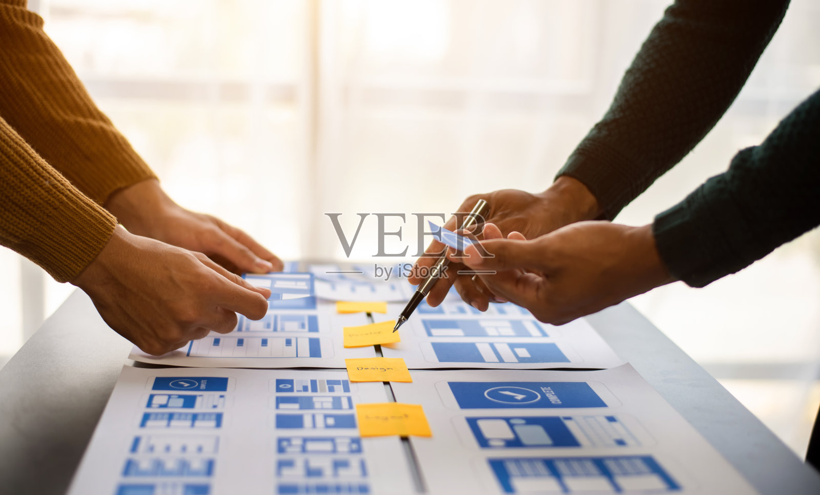 UX开发人员和ui设计人员在现代办公室里集思广益,根据客户简介和颜色代码设计移动应用程序界面线框。照片摄影图片