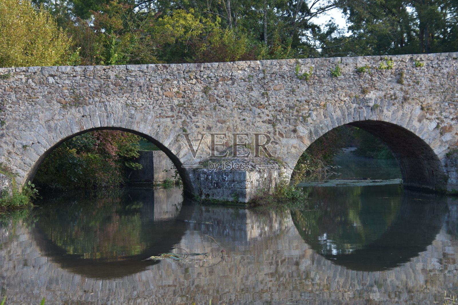 一座古罗马石桥和它在水中的倒影,在法国萨尔特州的伊夫勒维克照片摄影图片