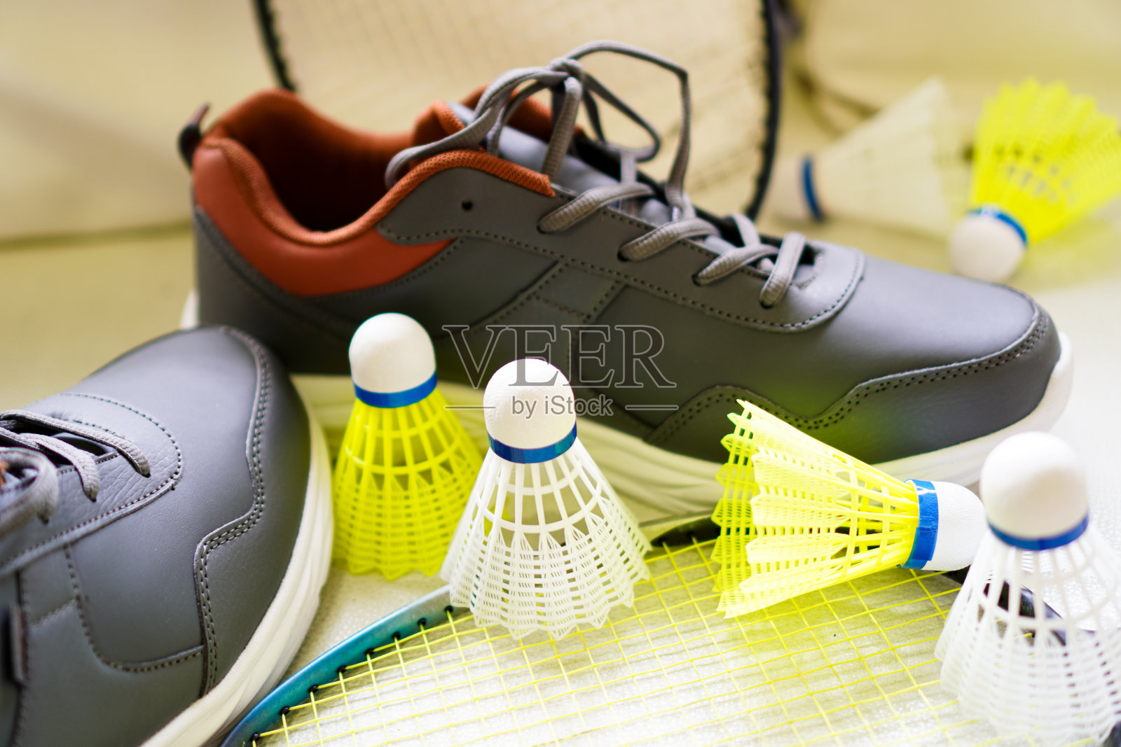 羽毛球组的图片,包括羽毛球拍,羽毛球和运动鞋在白色沙发上。照片摄影图片