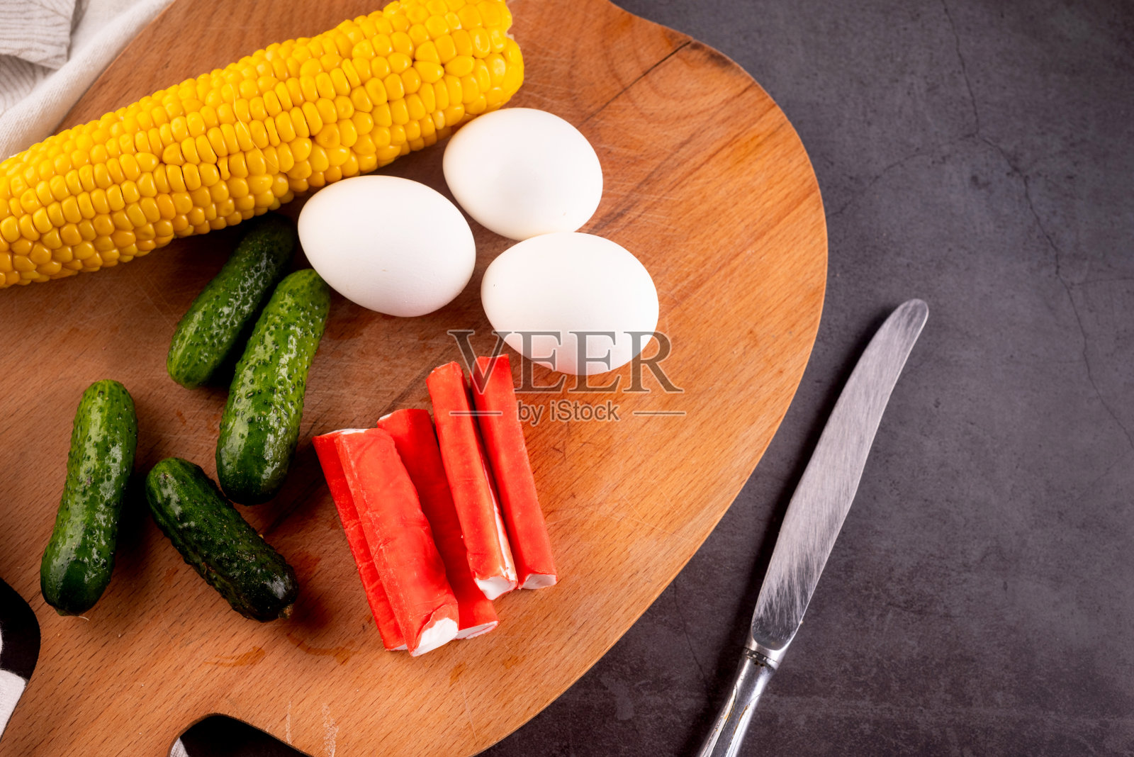 蟹肉棒沙拉材料:鱼糜、鸡蛋、玉米、黄瓜和酱料照片摄影图片