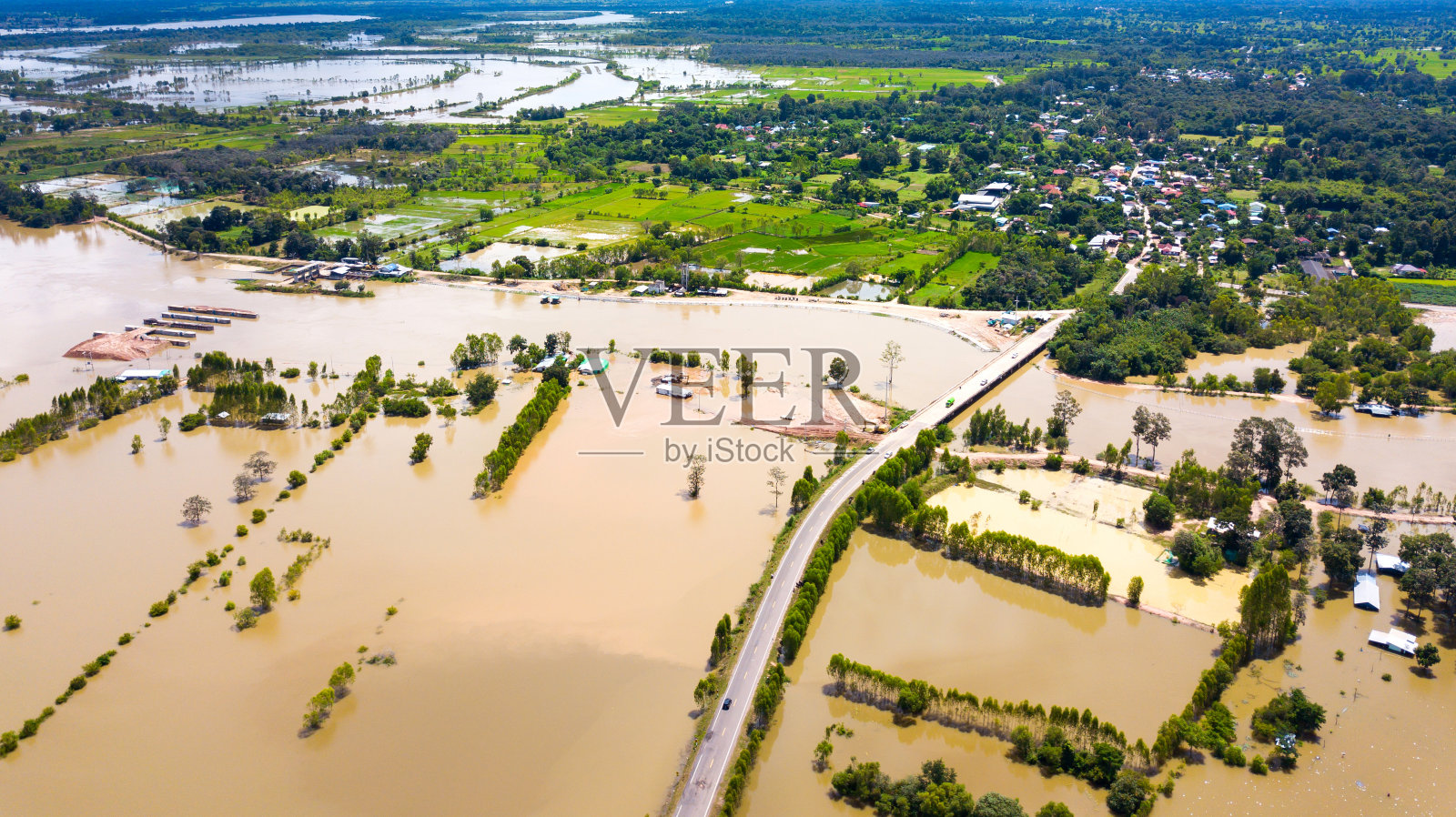 俯视图无人机拍摄的航拍照片。被淹的稻田。因自然灾害而使稻田淹水。从道路和桥梁上俯瞰,泰国,亚洲。照片摄影图片