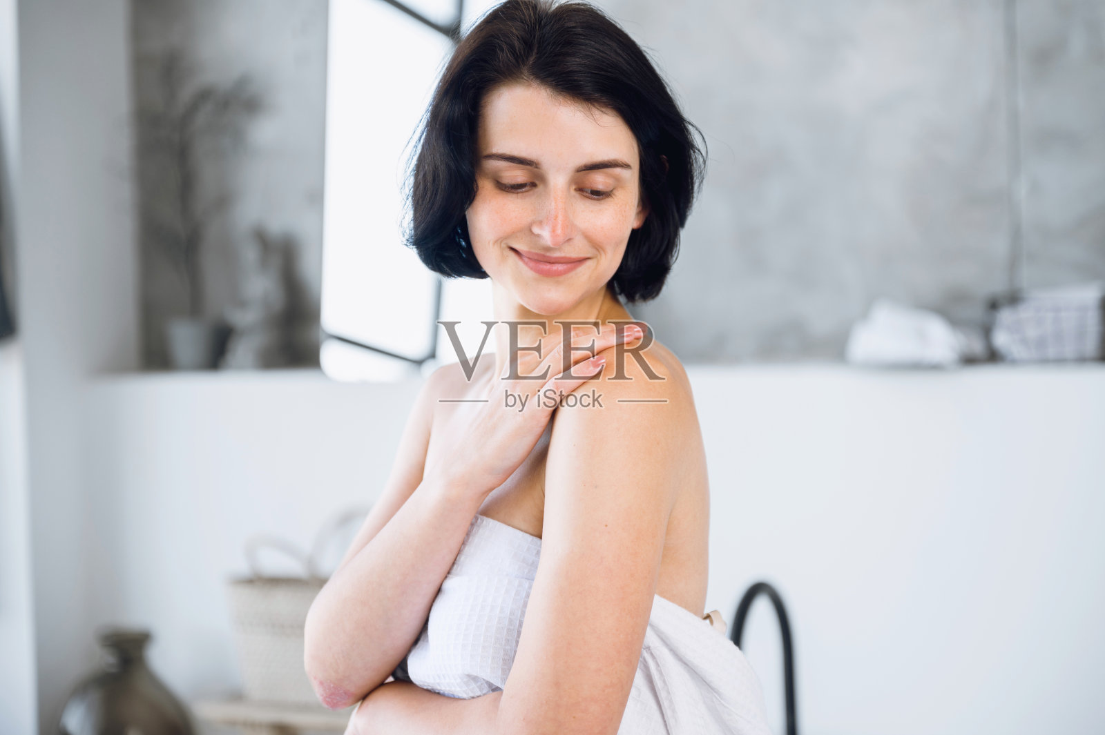 女士在润肤露或面霜后触摸柔软健康的身体皮肤照片摄影图片