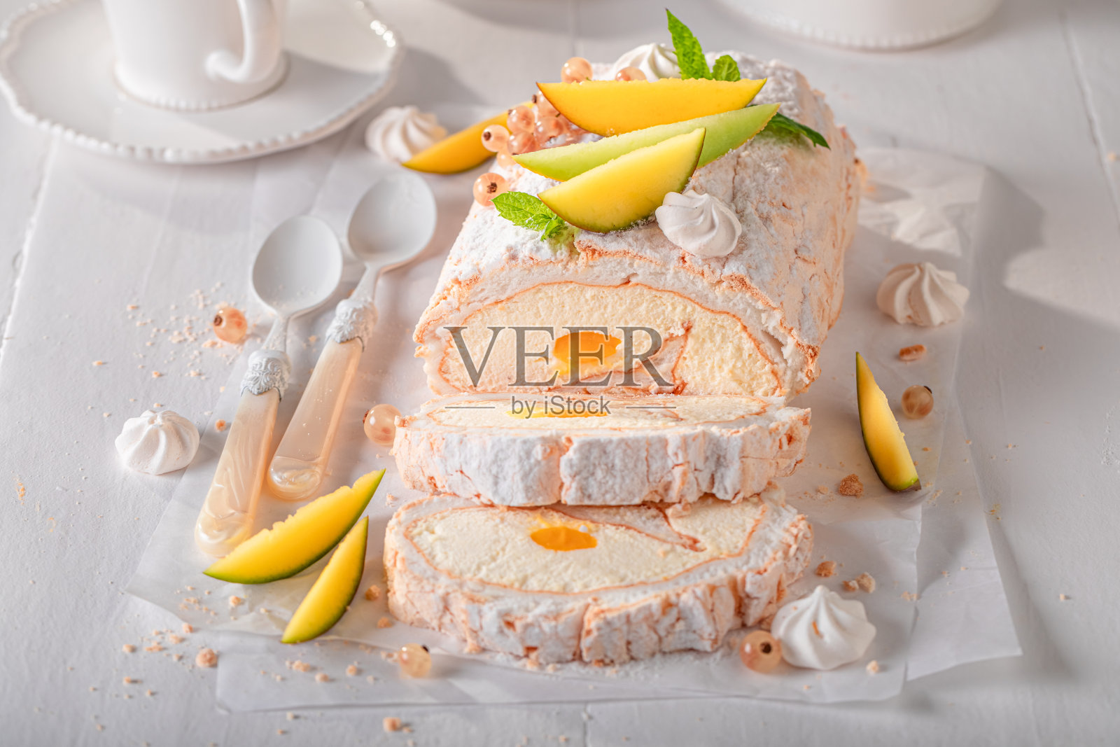 用热带水果自制的芒果瑞士卷。照片摄影图片