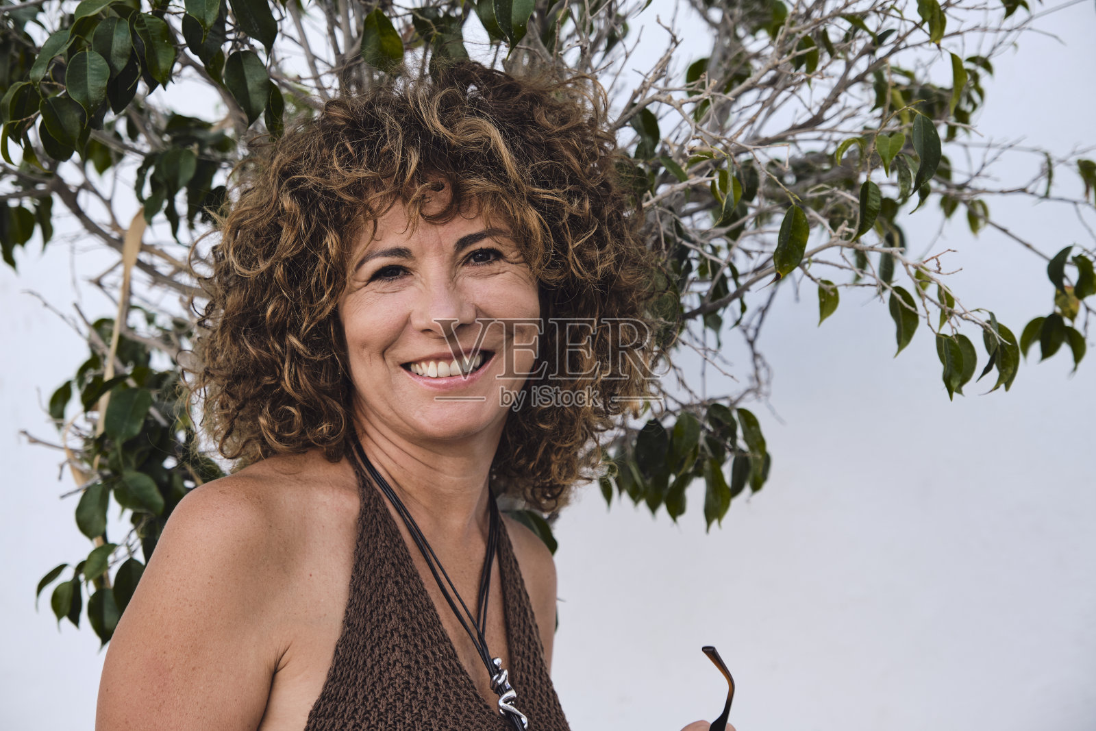 成年女子在白墙前摆姿势大笑照片摄影图片