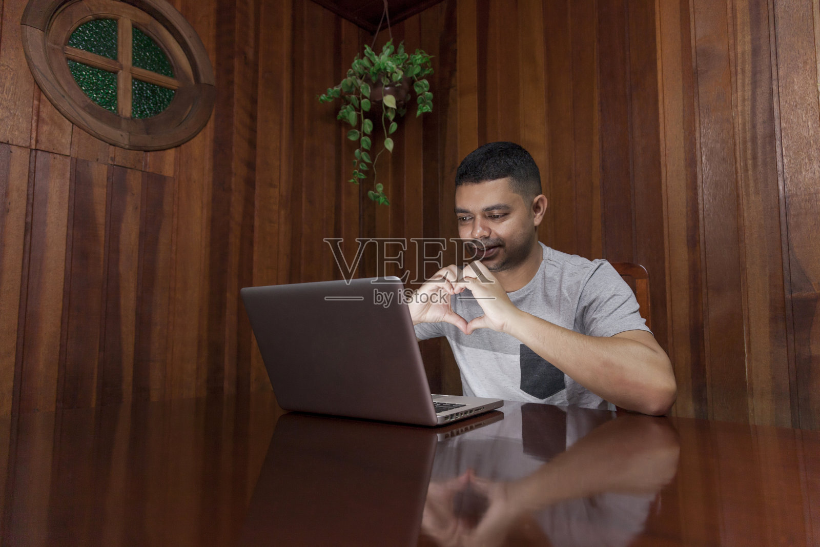 一个人在用笔记本电脑做表情。照片摄影图片