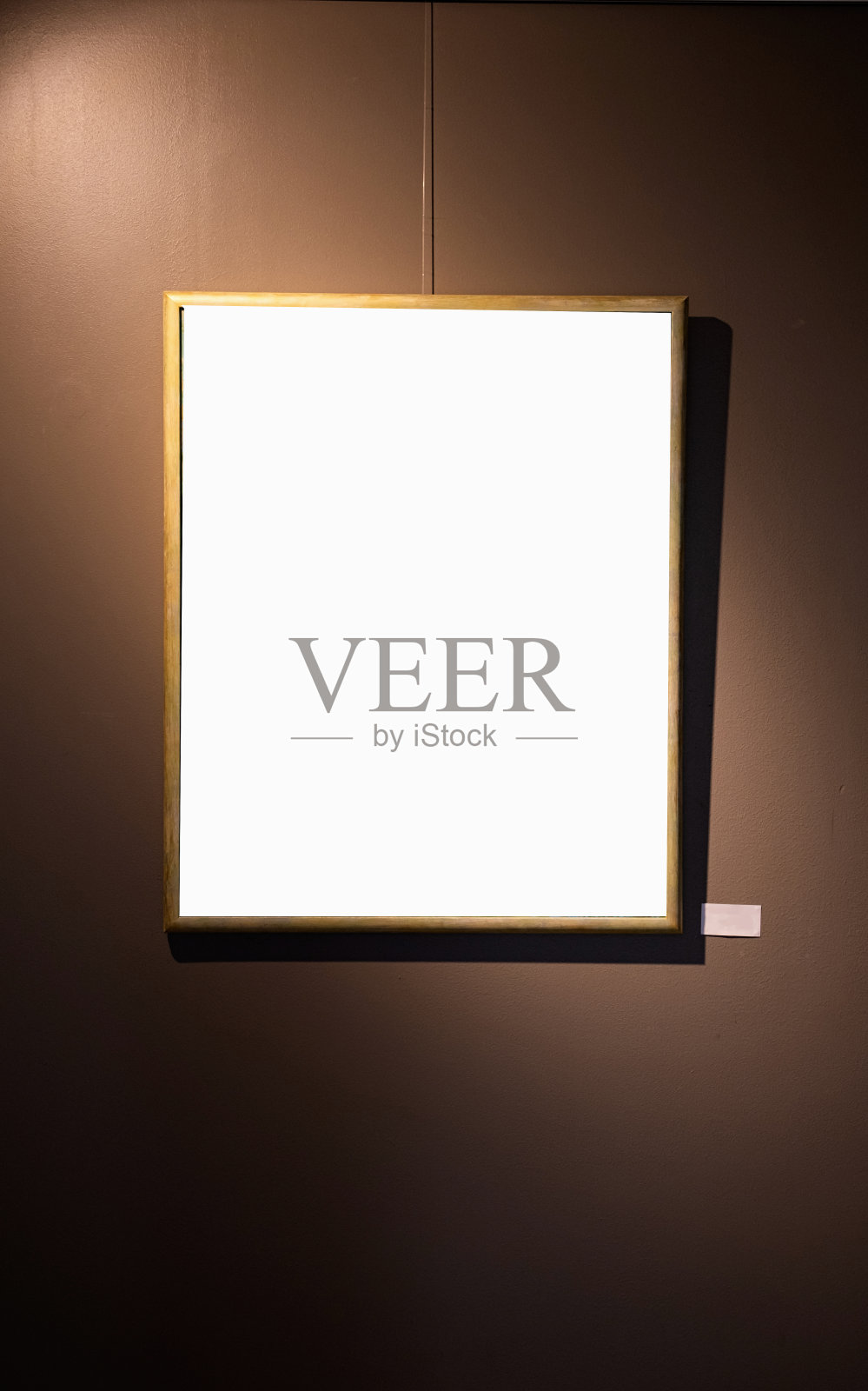棕色墙上的空白相框和发光的灯,模拟照片摄影图片