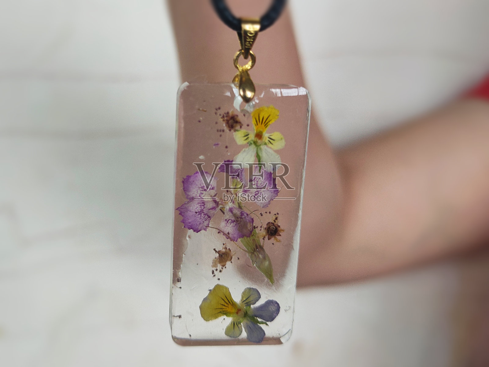 由环氧树脂和干花制成的挂件特写。照片摄影图片