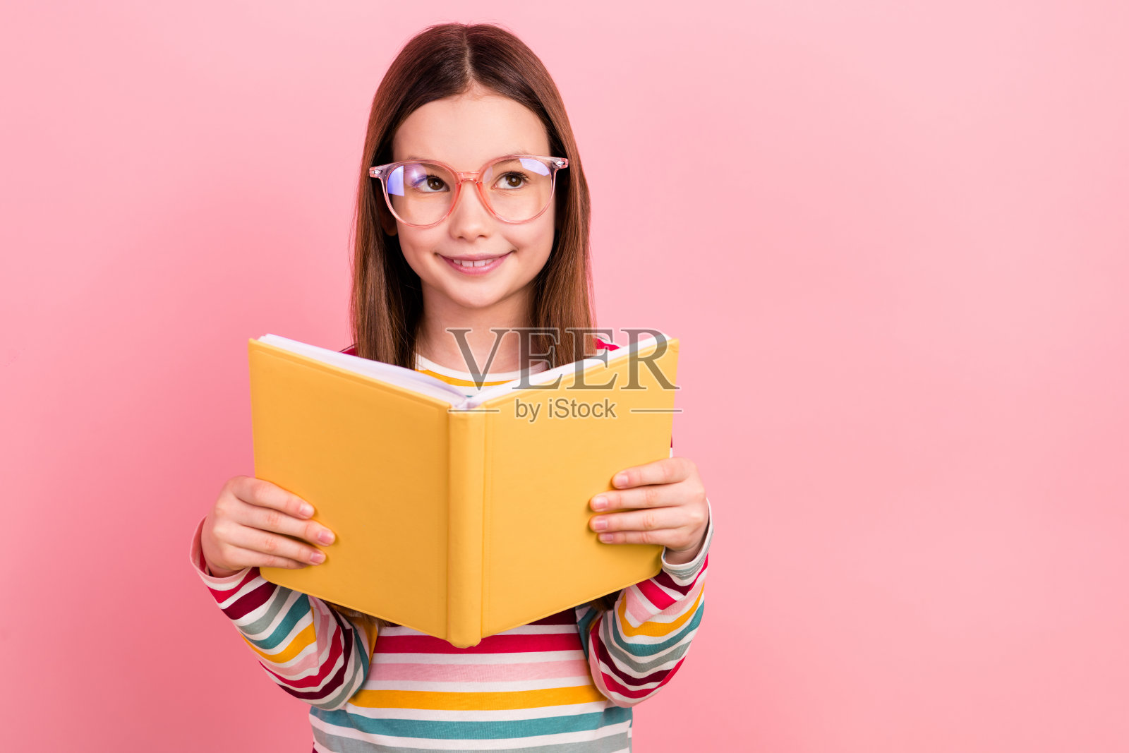 有思想的小女孩的照片阅读最喜欢的小说文学头脑看起来空白空间孤立在粉红色的背景照片摄影图片