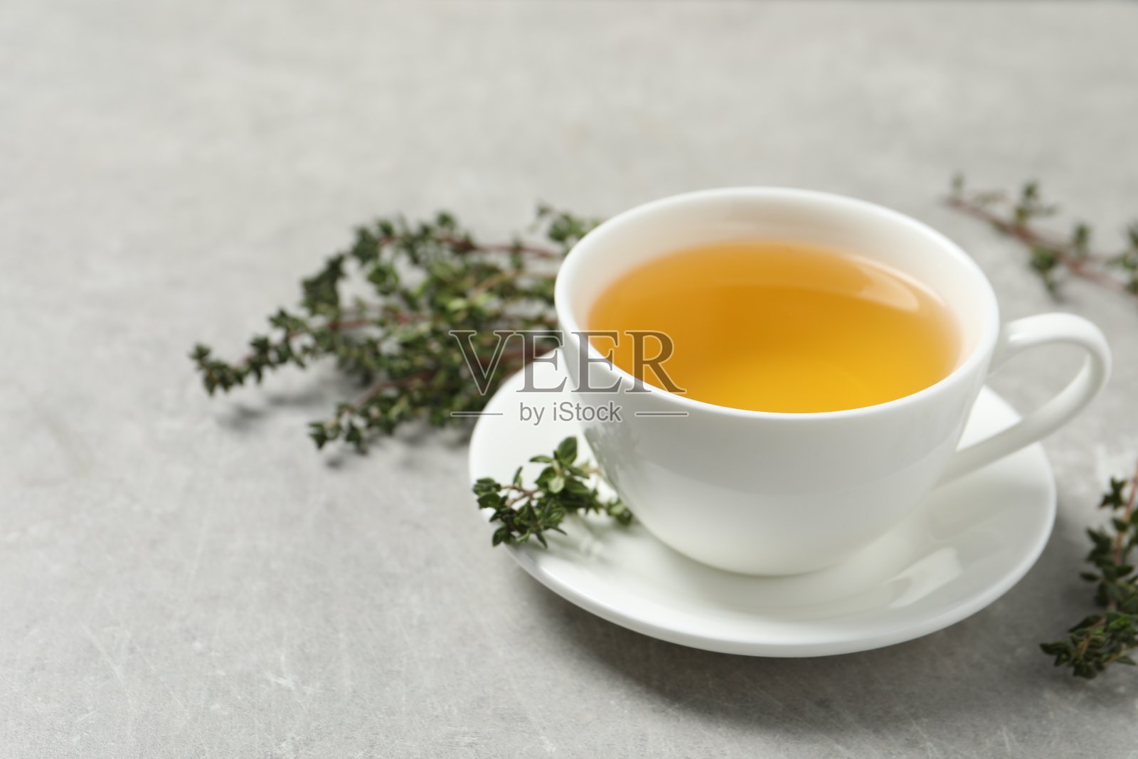 浅灰色餐桌上的百里香草本茶。文本空间照片摄影图片