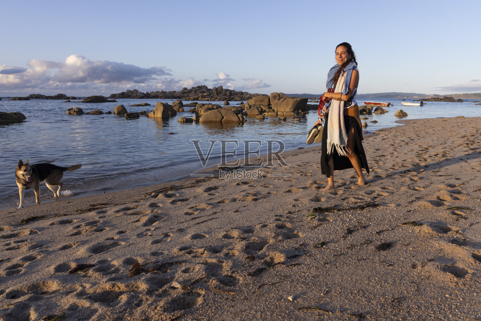 狗和女人在沙滩上散步照片摄影图片