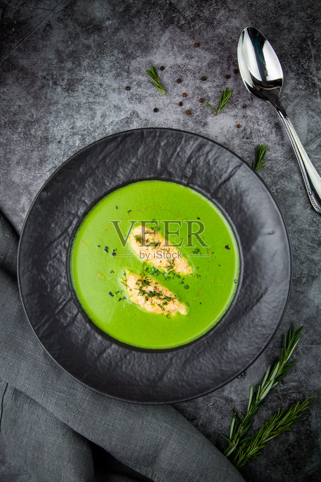 奶油花椰菜汤,肉和莳萝在黑色盘子照片摄影图片