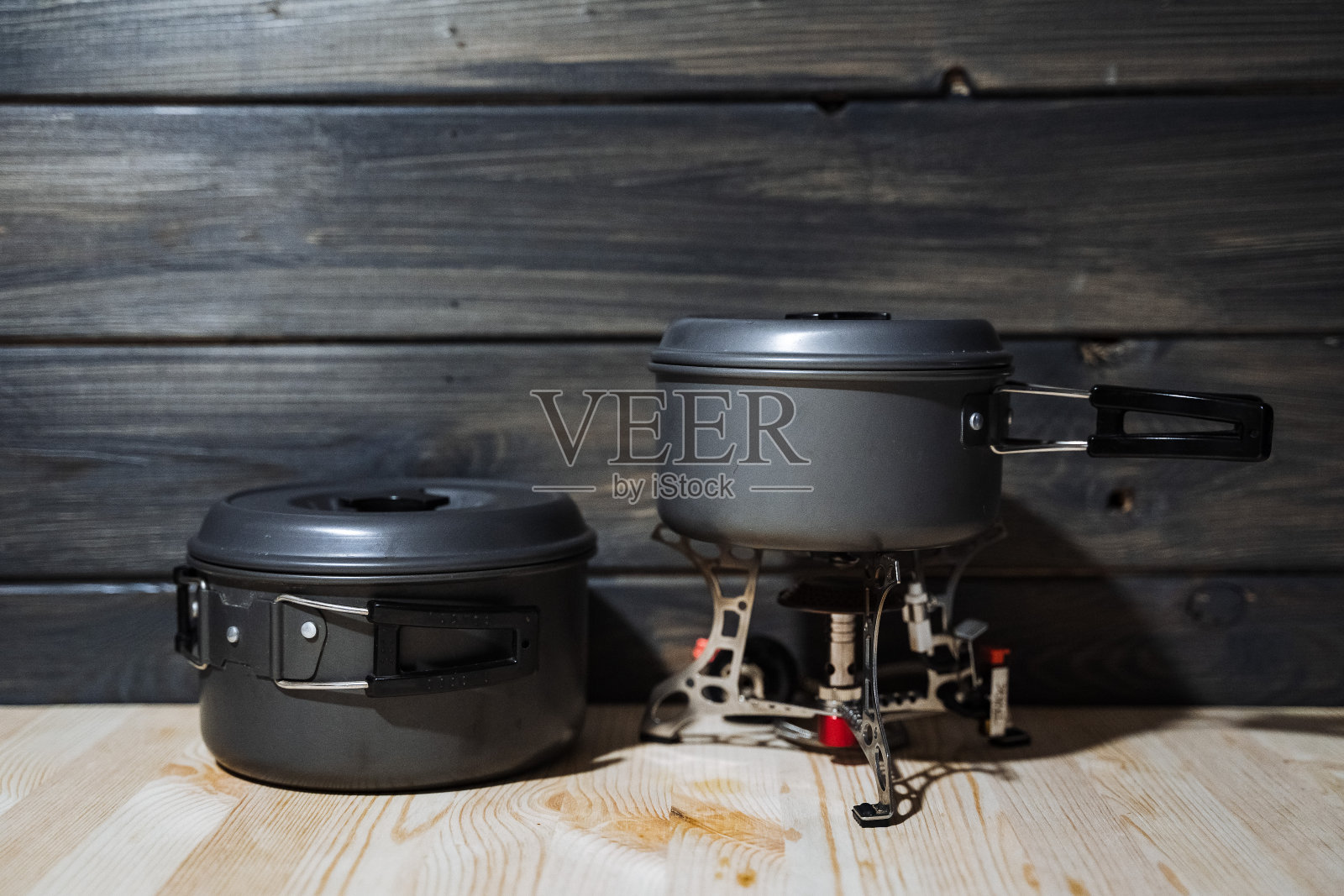 一套野营用具。便携式燃烧器和深色不锈钢锅。露营,在户外吃饭。煤气灶照片摄影图片