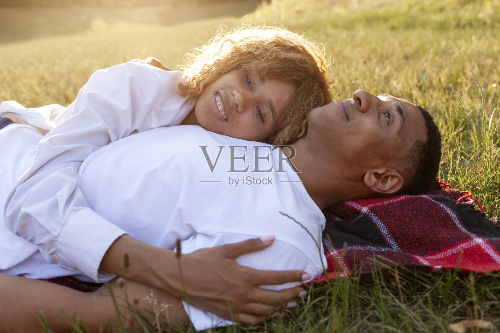 非洲裔美国浪漫的年轻夫妇躺在公园的草地上,睡在大自然中,幸福的家庭休息照片摄影图片
