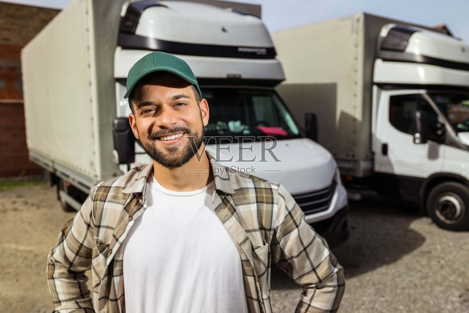 快乐自信的男司机站在他的卡车前面照片摄影图片