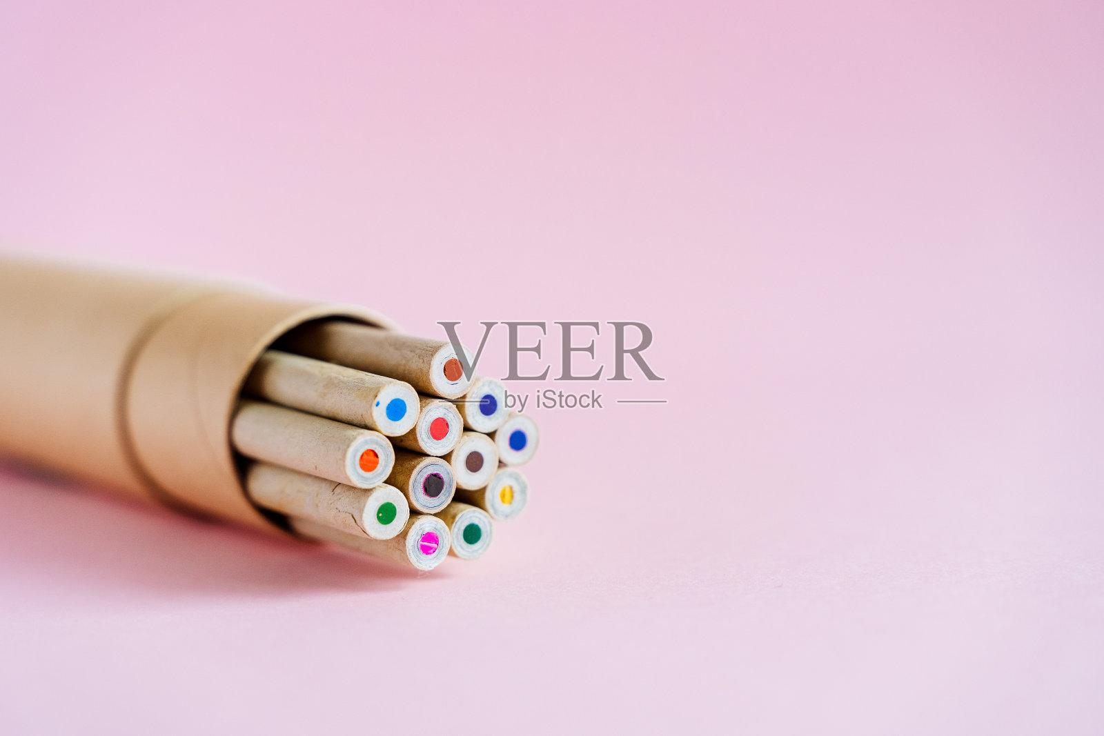 粉红色背景上的一盒铅笔。孩子们用天然木材做的彩色铅笔。包装方便-纸板箱。一套12种原色。画照片摄影图片