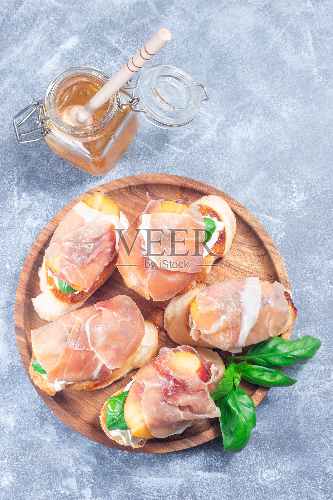 火腿桃意式烤面包。克罗斯蒂尼,奶油奶酪,罗勒,桃子和熏火腿,垂直,俯视图照片摄影图片