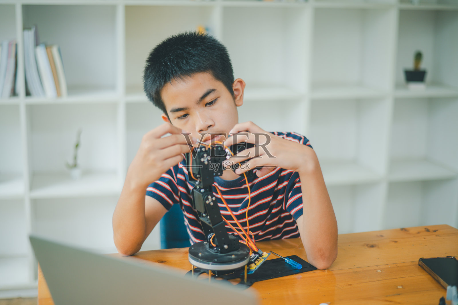 亚洲男孩学习和研究技术机器人的工作。家庭教育和科学换技术项目。童年玩耍,孩子爱好,休闲生活,人们玩具,机器人技术。照片摄影图片