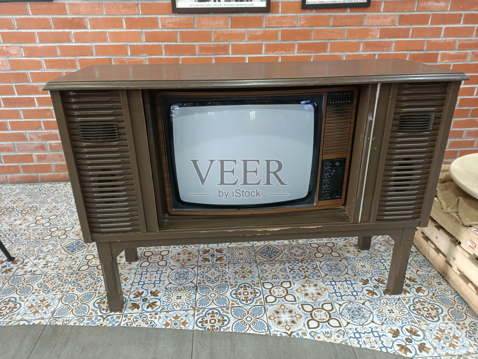 老式木制电视在一个房间与红砖墙背景照片摄影图片