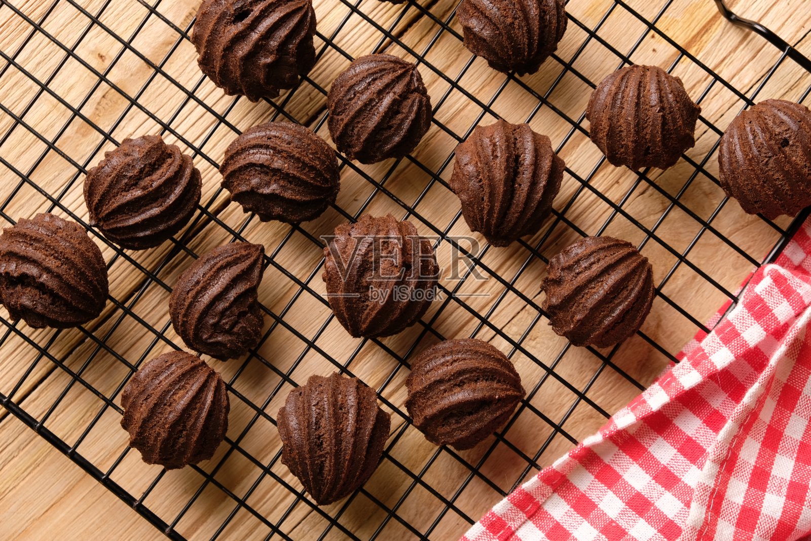 巧克力泡芙放在冷却架上。甜糕点是由小麦粉、鸡蛋、巧克力、糖制成的。模糊的形象。照片摄影图片
