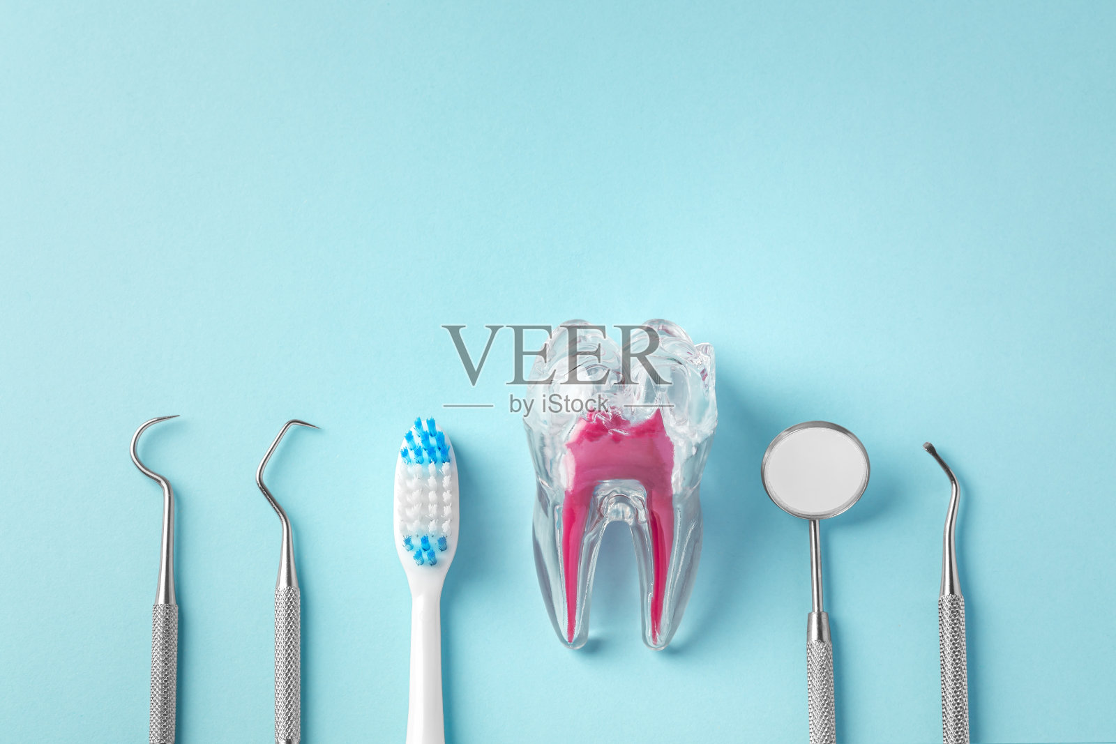 牙齿保健概念,蓝色背景的牙齿,牙刷和牙科工具照片摄影图片