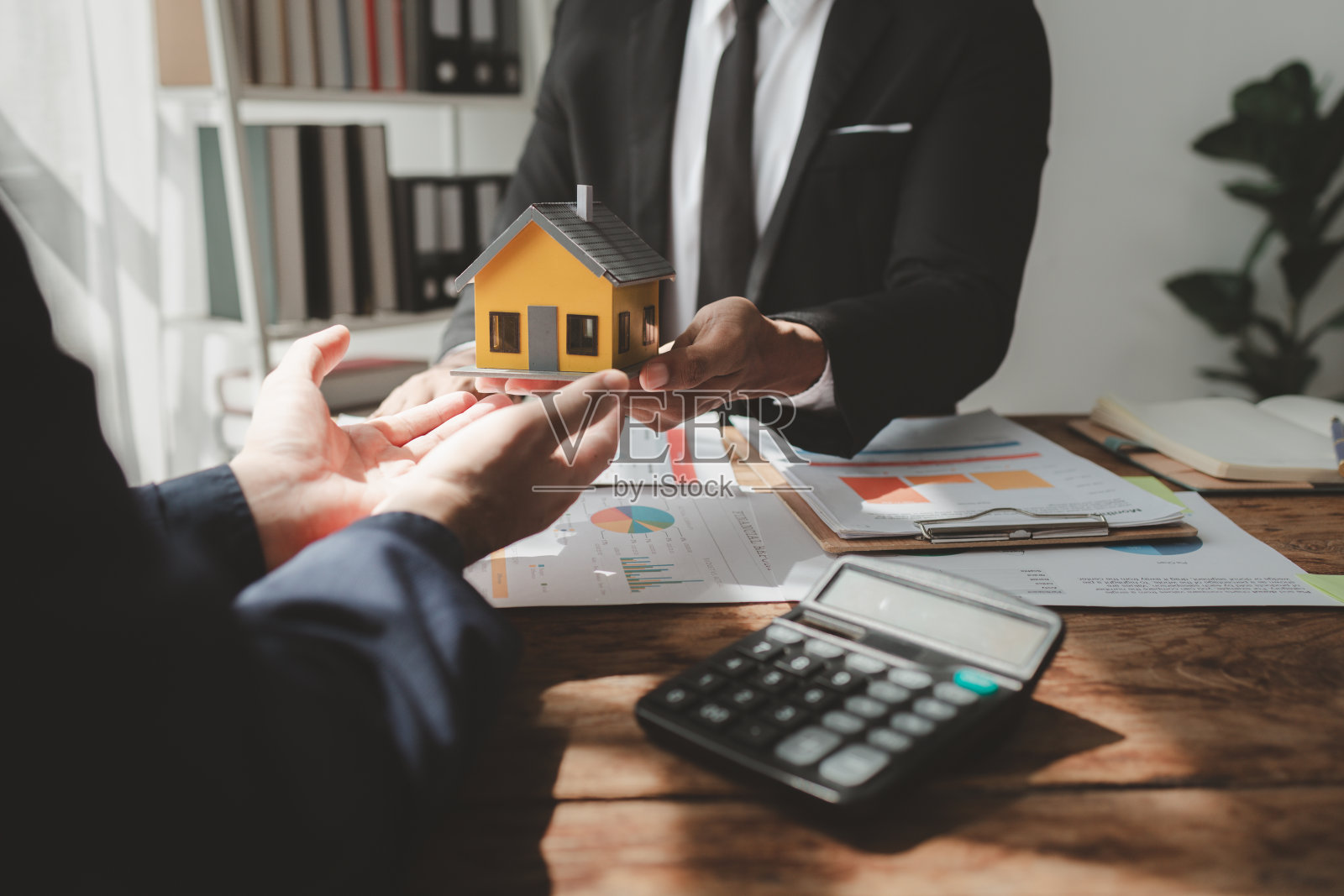 与房地产专家谈话讨论房地产投资一位客户正在与投资专家就购买房屋和房地产的想法进行财务会议。照片摄影图片