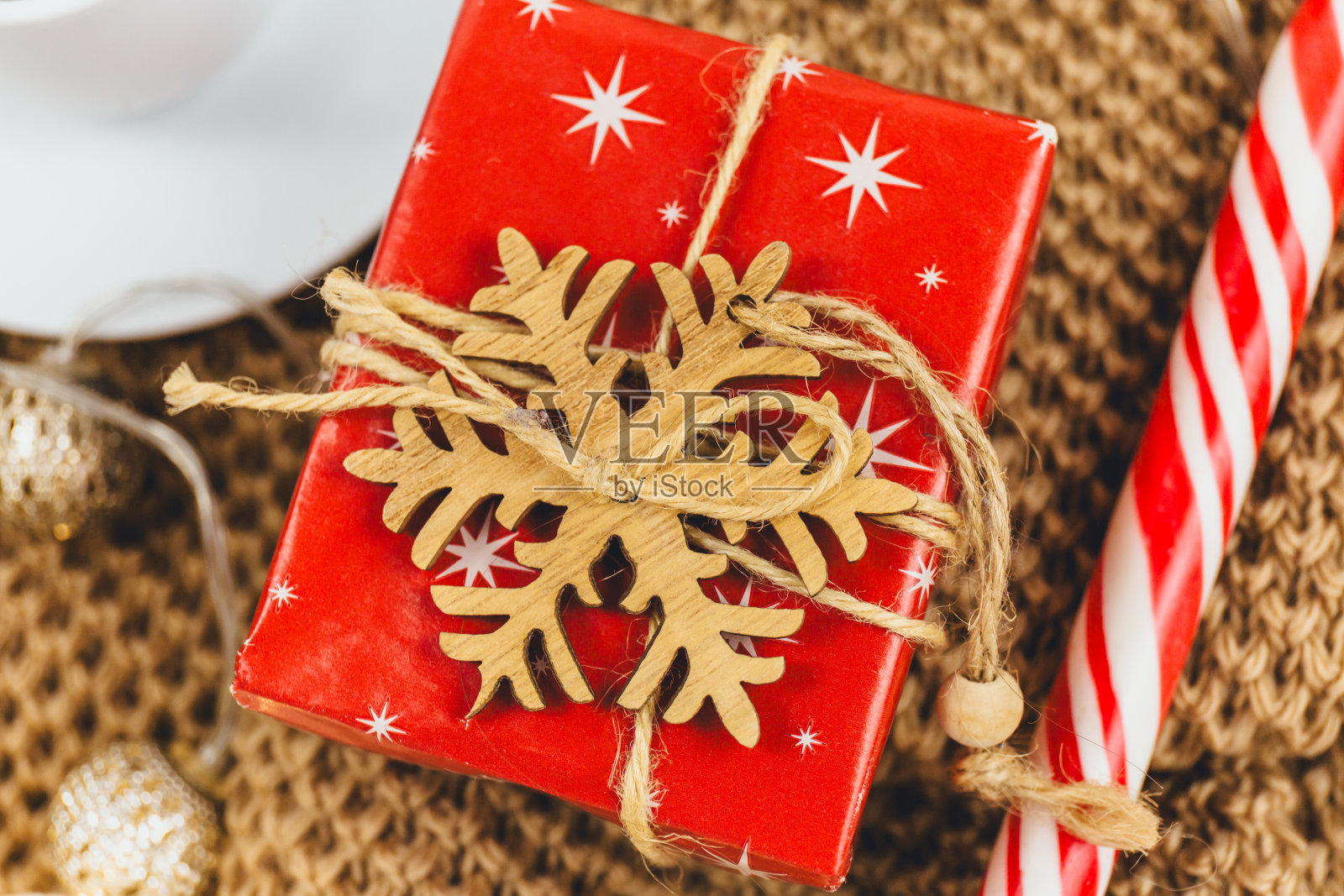红色圣诞礼盒与米色背景丝带。中国新年装饰。Hygge风格,冬季概念。舒适的家庭书桌。新年和圣诞节庆祝模型。圣诞静物照片摄影图片