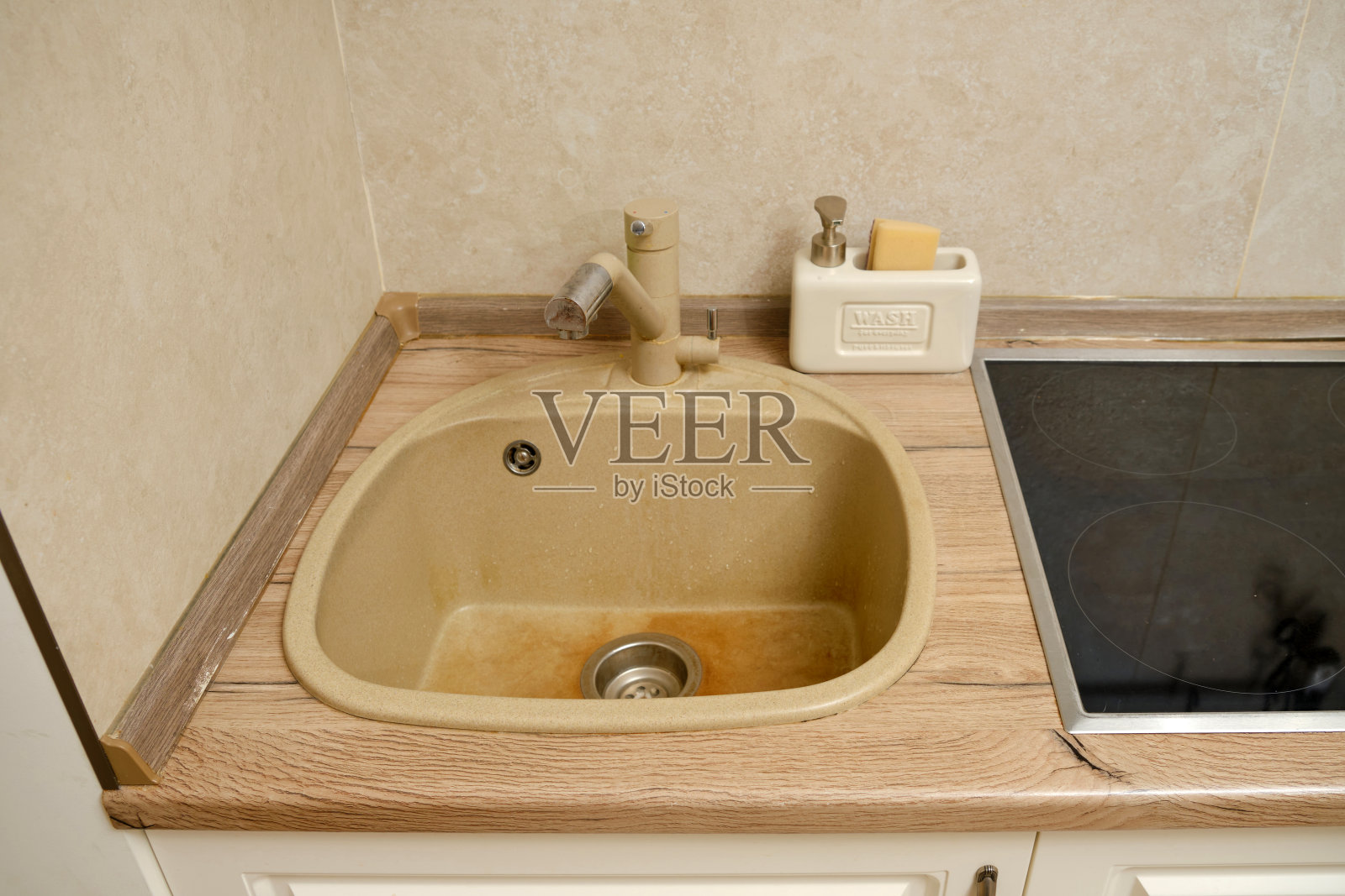 厨房水槽上的黄色斑块。洗完脏盘子后,厨房水槽空了照片摄影图片