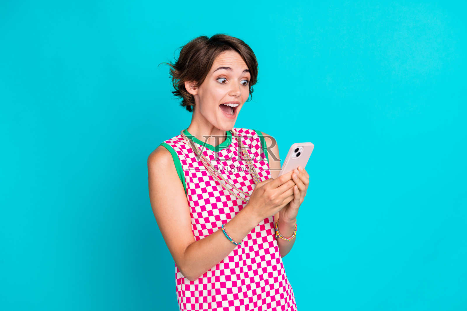 年轻有趣的照片惊讶鲍勃棕色头发的女士震惊地看着她的手机电子银行收到的钱孤立的海蓝宝石色背景照片摄影图片