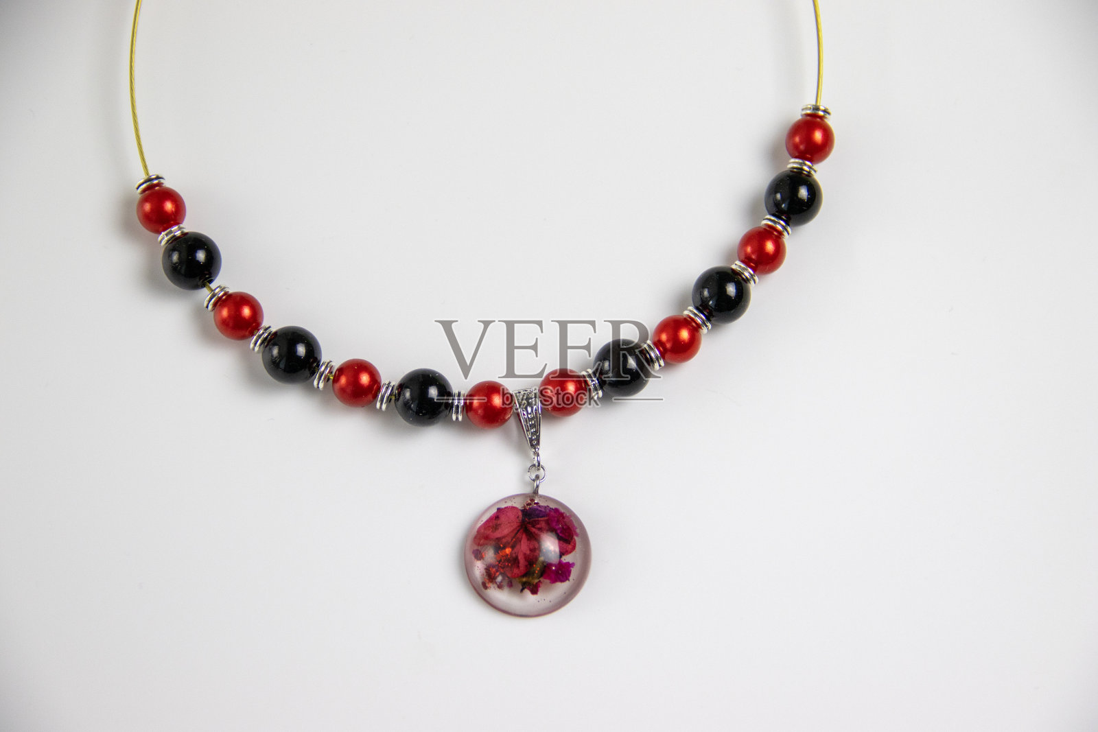 用环氧树脂和天然花朵制作的DIY服装首饰,DIY首饰大师。美丽的耳环和吊坠在家里制作的珠宝树脂。照片摄影图片