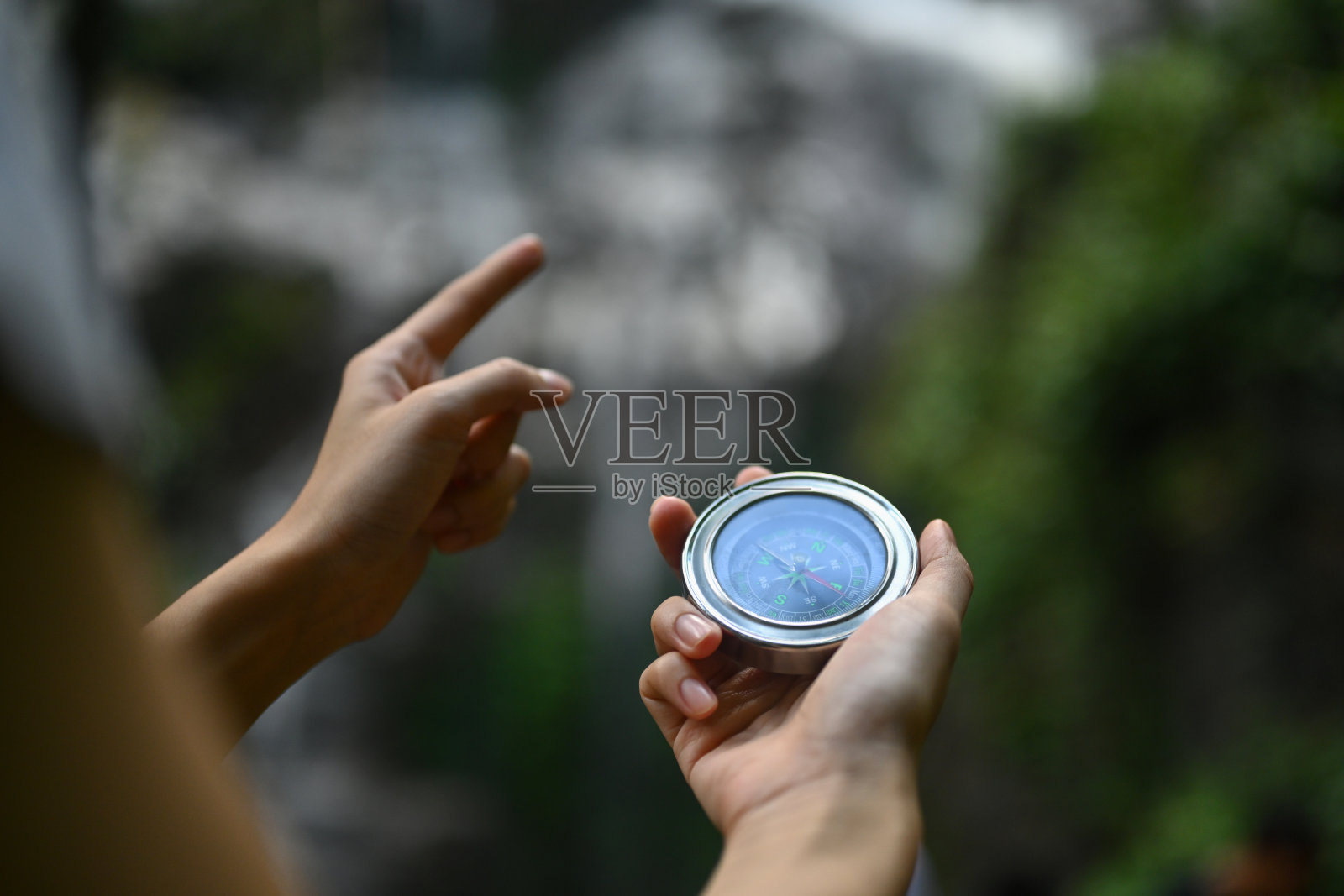 无法辨认的男性徒步旅行者在森林中探索大自然时用指南针指引方向照片摄影图片