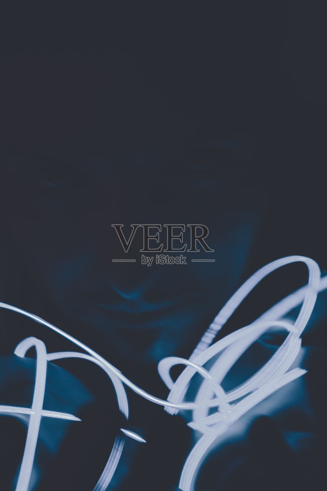 黑色背景下的霓虹灯在黑暗中围绕着一张人脸照片摄影图片