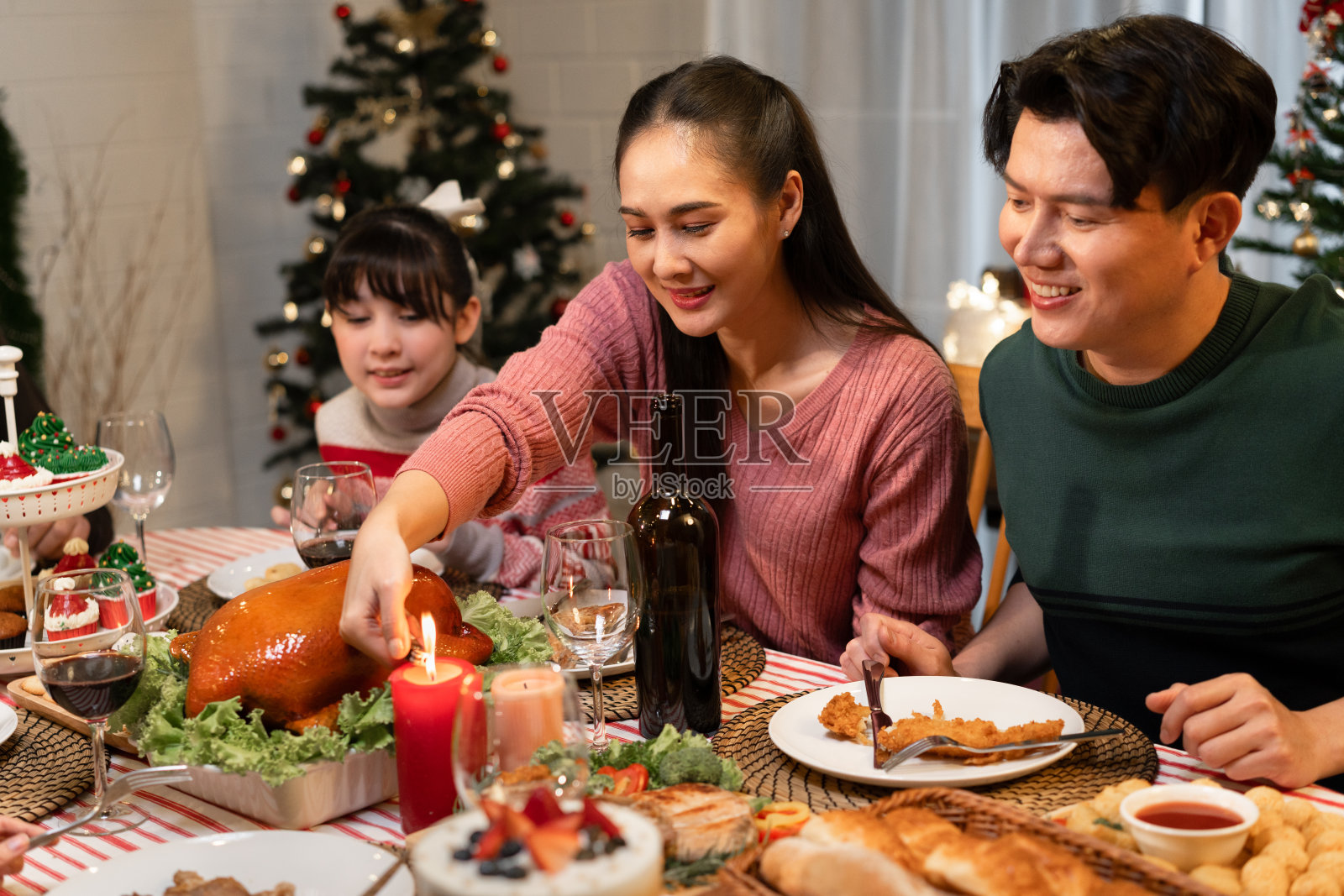 快乐的亚洲家庭,母亲,父亲和女儿在家里吃晚餐庆祝圣诞节照片摄影图片