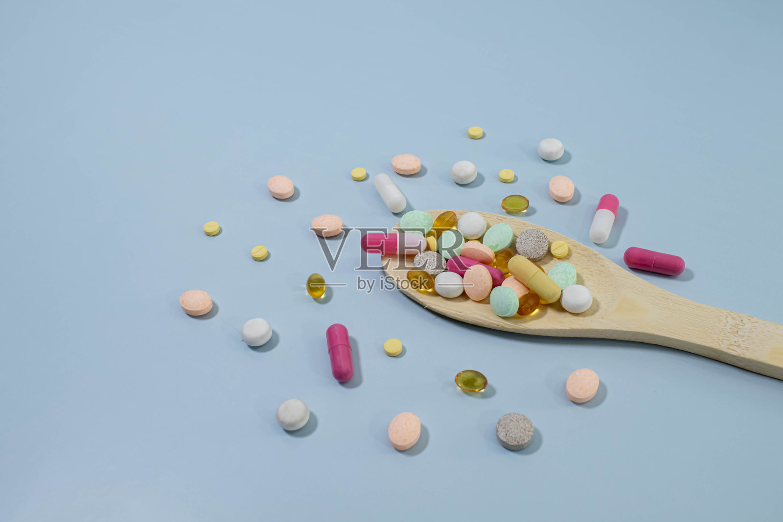 木勺里装着各种药片和胶囊照片摄影图片