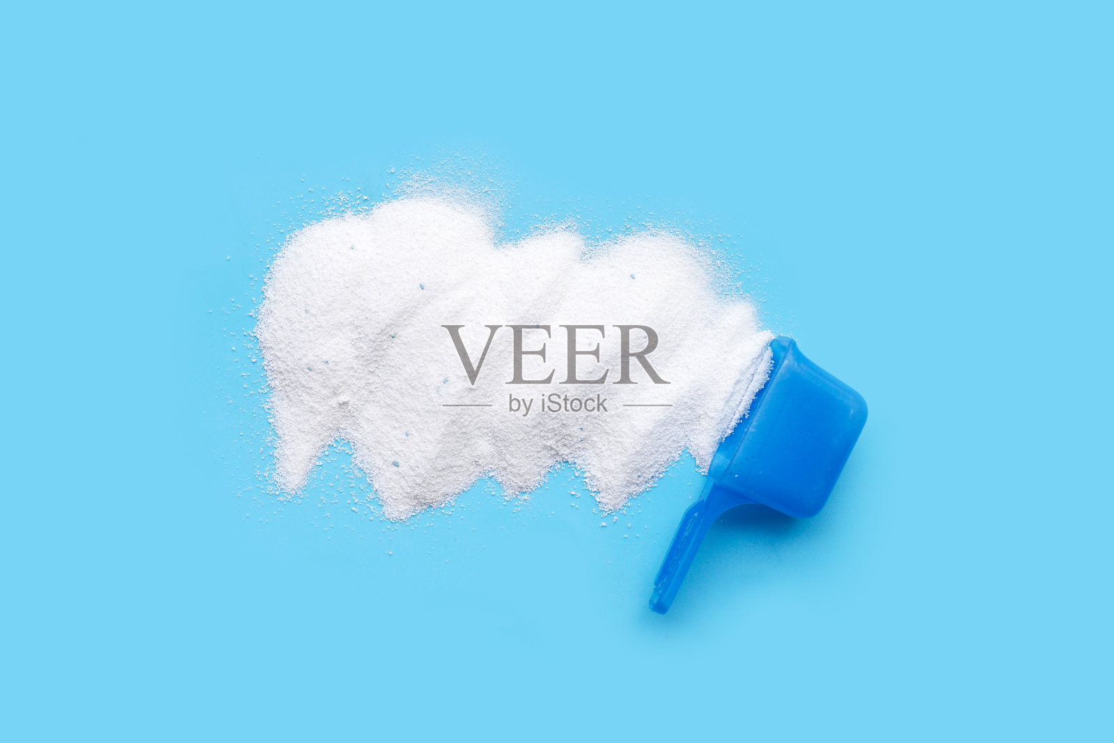 用量勺测量洗衣粉。衣服的概念。照片摄影图片