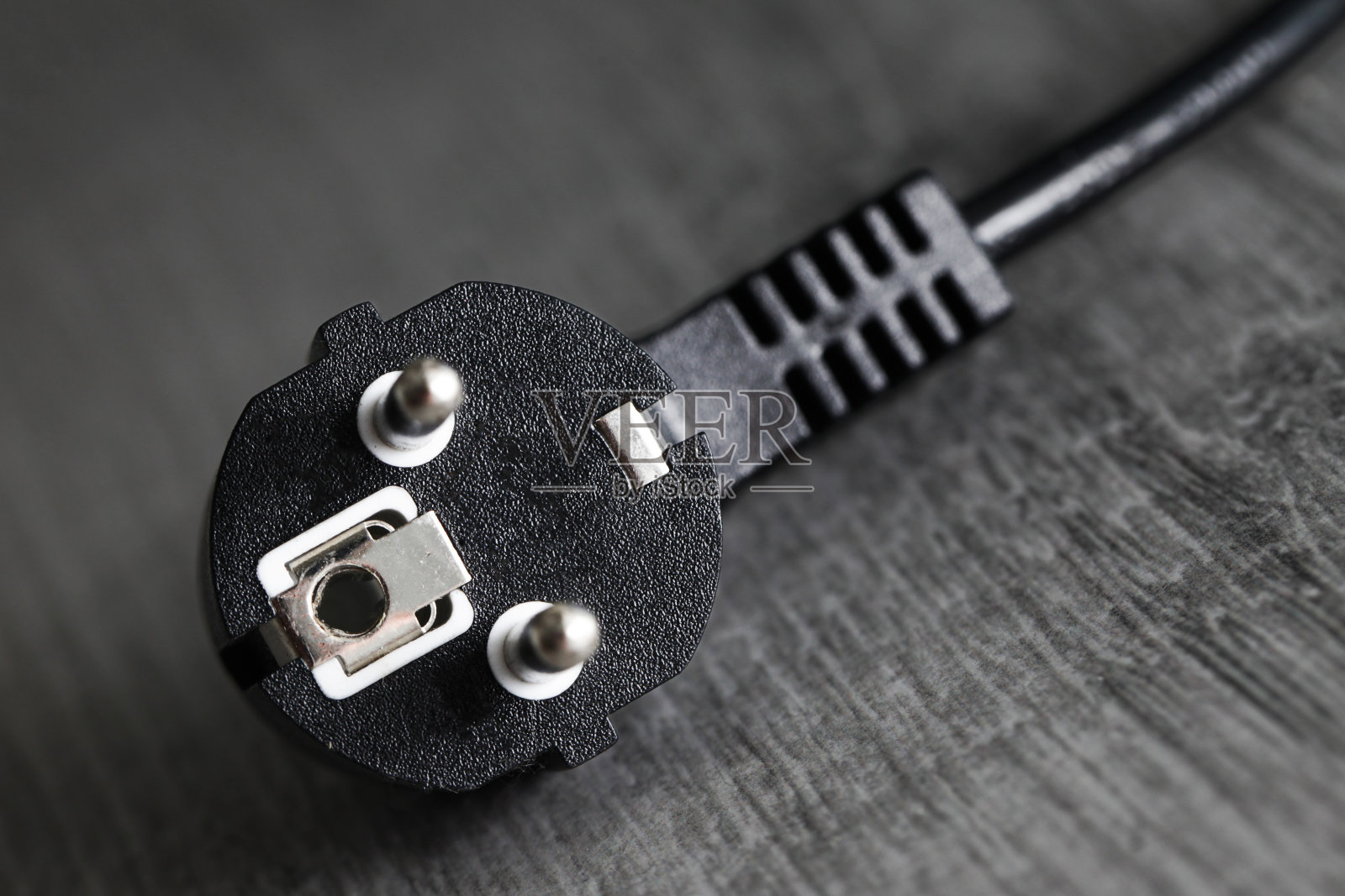 电源插头隔离。黑色接地欧洲插头电源隔离在木地板上。照片摄影图片