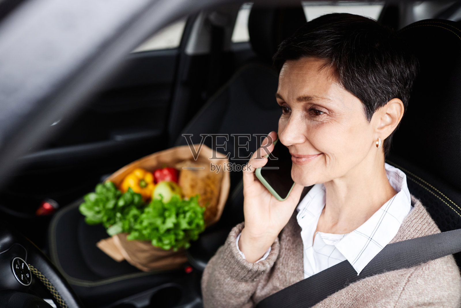微笑的女人在车里打电话照片摄影图片
