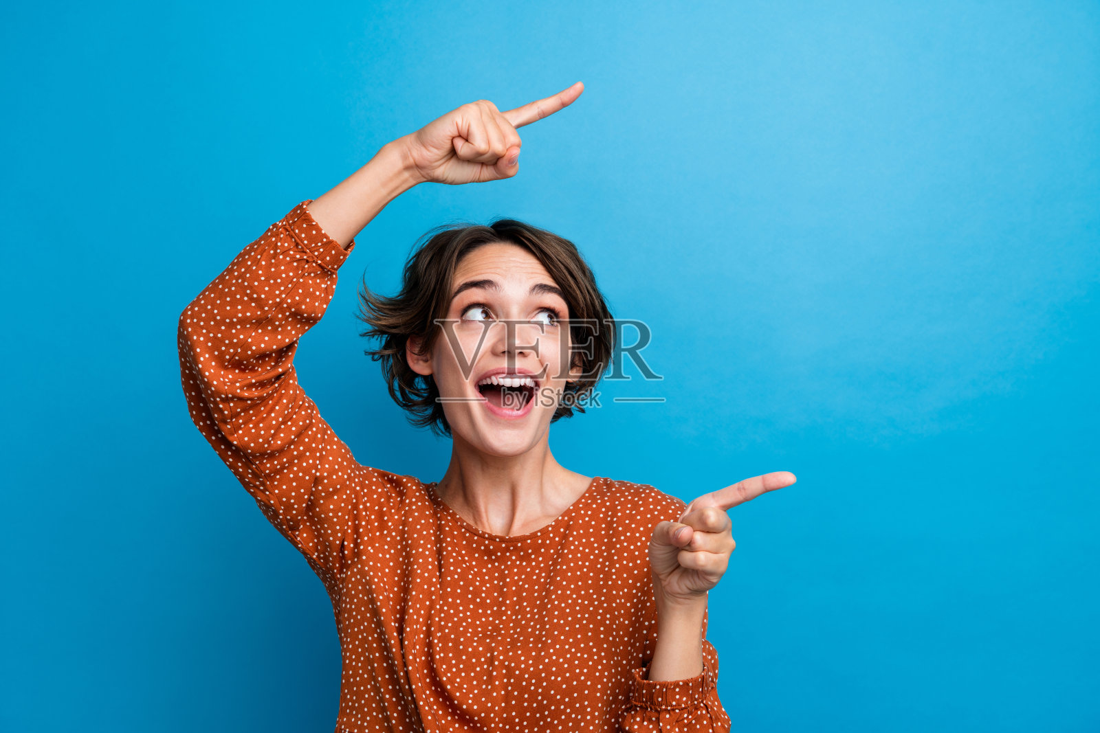 图为激动的女士促销员指导手指空空间销售购物时尚人士孤立的蓝色背景照片摄影图片